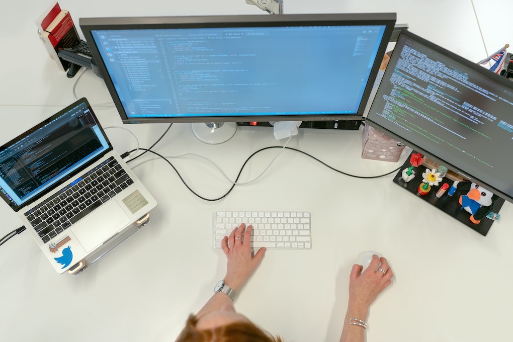 person on computer with multiple screens