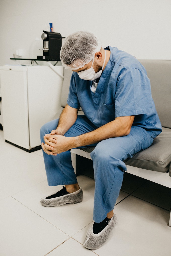 dentist with hands folded and looking at the floor